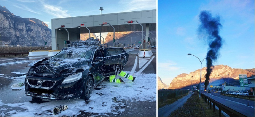 Un'auto avvolta dalle fiamme all'uscita dell'A22, una densa colonna di fumo nero si alza in cielo